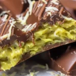 Close-up of Dubai chocolate bar with creamy green filling and white chocolate shavings