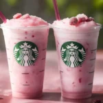 Iced Starbucks pink drink with freeze-dried strawberries in clear plastic cup
