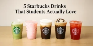 Five Starbucks drinks lined up on a light wooden table, including Iced Matcha Latte, Pink Drink, Vanilla Sweet Cream Cold Brew, Iced Mocha with whipped cream, and Strawberry Açaí Refresher, with the title "5 Starbucks Drinks That Students Actually Love" above them.