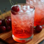 How to Make a Dirty Shirley Cocktail at Home Dirty Shirley cocktail in a glass with ice and cherry – perfect 3 ingredient student drink