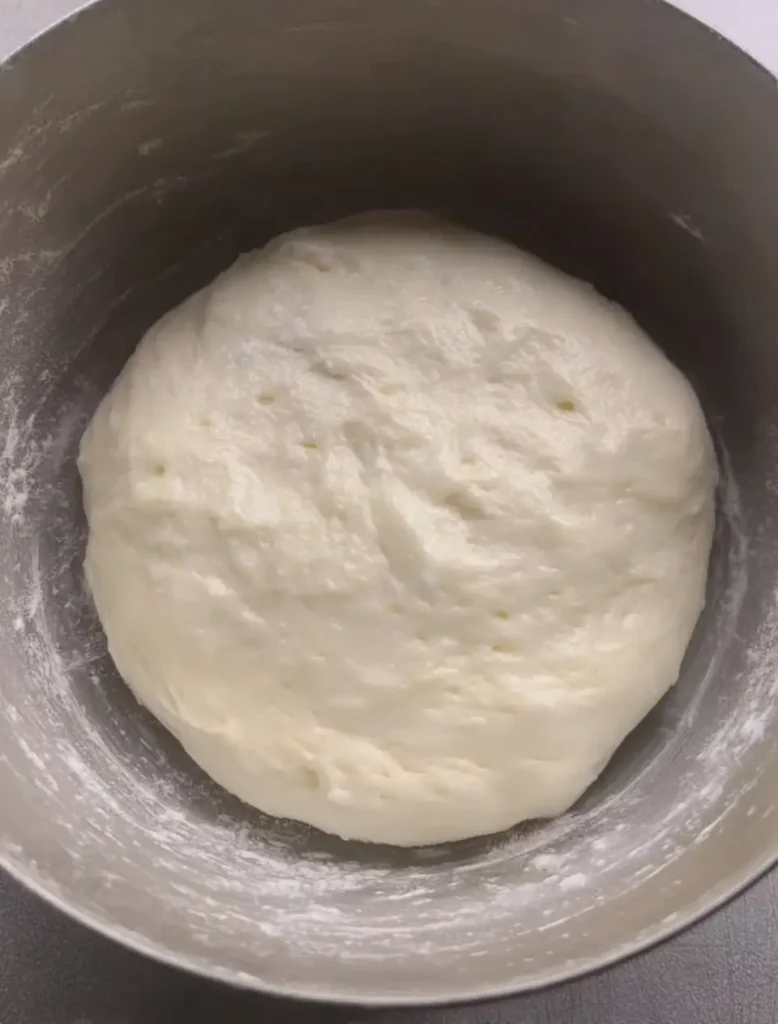 Cloud Toast Bread dough after the first rise in a bowl — smooth, puffy, and airy, ready to shape.