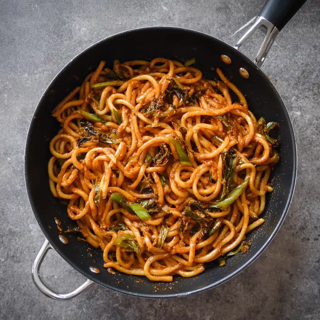 Student Budget Recipes: 12 Dorm-Friendly, Trendy & Cheap Ideas 5 One-pan gochujang tahini udon noodles with vegetables in a skillet – quick 15-minute spicy Asian fusion recipe.