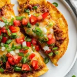 Homemade Taco Bell Mexican Pizza on a white desk with bright lighting, topped with melted cheese, diced tomatoes, and green onions.