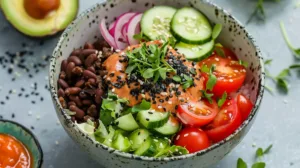 Vegetarian burger bowl with beans, lettuce, tomatoes, cucumbers, and vegan sauce.
