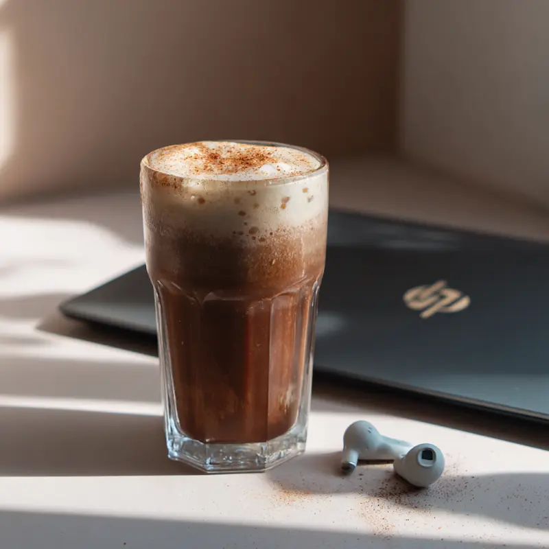 Iced chocolate protein cold brew in a clear glass with cinnamon dust on top