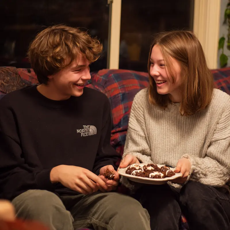 Mascarpone Stuffed Dates with Maple Drizzle — A Fancy Snack on a Student Budget! 4 Students on a couch sharing a small platter of mascarpone stuffed dates during a movie night