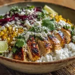 Overhead shot of a colorful street corn chicken bowl with grilled chicken, rice, charred corn, and lime wedges — perfect easy meal for students.