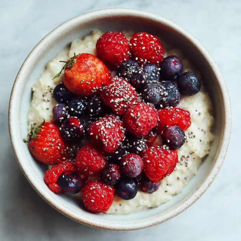 Vanilla protein oatmeal topped with juicy microwaved berries and chia seeds