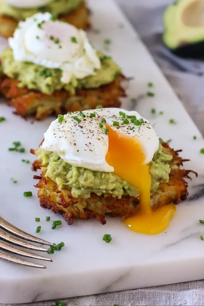 Potato avocado toast made with crispy potato patties, mashed avocado, and a perfectly poached egg on top.