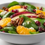 Winter Salad with Honey Mustard Dressing and Mandarin Orange Segments Winter salad with mandarin orange segments and honey mustard dressing on white background