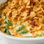 Cheesy asparagus casserole baked with Ritz crackers in a white ceramic baking dish, golden and bubbly