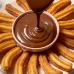 Homemade churros coated in cinnamon sugar served with chocolate dipping sauce, easy churros recipe