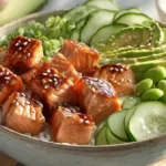 Teriyaki salmon sushi bowl with glazed salmon, sushi rice, avocado, cucumber, and edamame in a ceramic bowl.