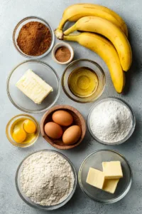 Ingredients for an easy banana bread recipe including ripe bananas, flour, sugar, eggs, butter, and baking soda