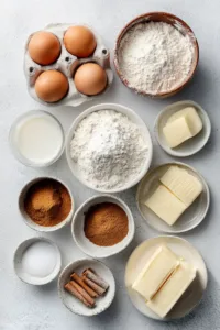 Spanish Churro Pancakes: The Ultimate Sweet Breakfast Treat 5 Flat lay of ingredients for Spanish churro pancakes including flour, eggs, milk, cinnamon, sugar, butter, and baking powder