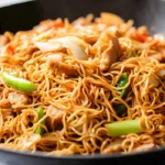 Easy chicken chow mein recipe with noodles, chicken breast, vegetables, and savory sauce in a wok