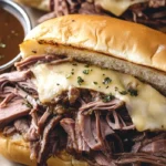 Easy French dip sandwiches with au jus served on toasted hoagie rolls with sliced roast beef and melted provolone cheese.