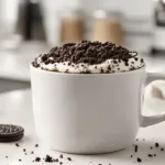 Oreo Mug Cake: Easy 3-Ingredient Dessert 3-ingredient Oreo mug cake in a white mug topped with crushed Oreo cookies