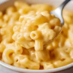 Microwave mac and cheese in a mug with creamy cheddar sauce in a modern American kitchen.