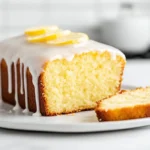 Starbucks Copycat Lemon Loaf Recipe Starbucks Copycat Lemon Loaf with glossy lemon glaze on a serving plate in a bright modern American kitchen.